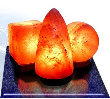 Group of three lit shaped salt lamps on a table